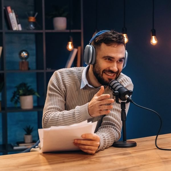 In headphones. Man is on the radio doing podcast live.